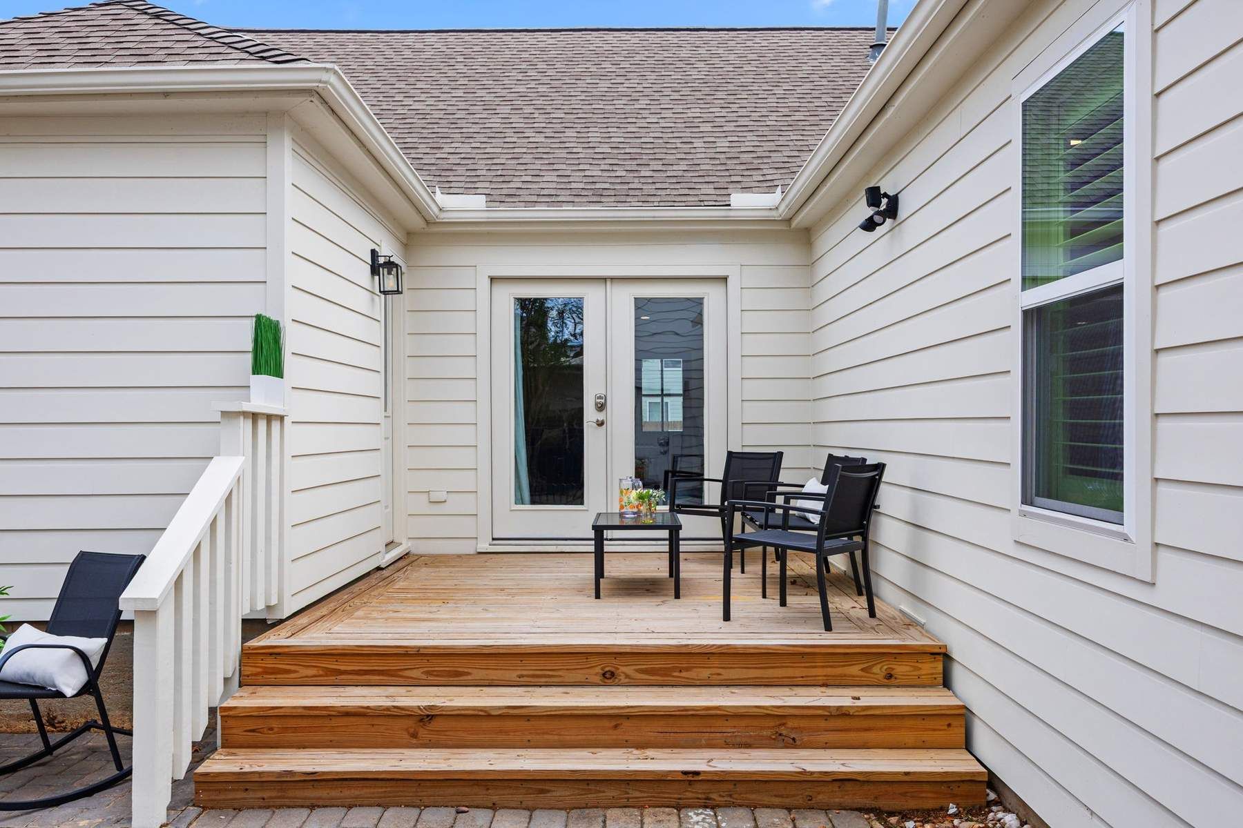 Finished rear exterior with new lap siding, French doors, and a wood deck